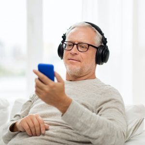 happy senior man with smartphone and headphones