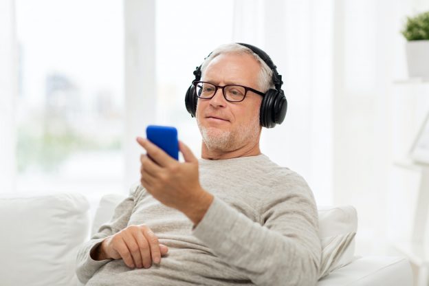 happy senior man with smartphone and headphones